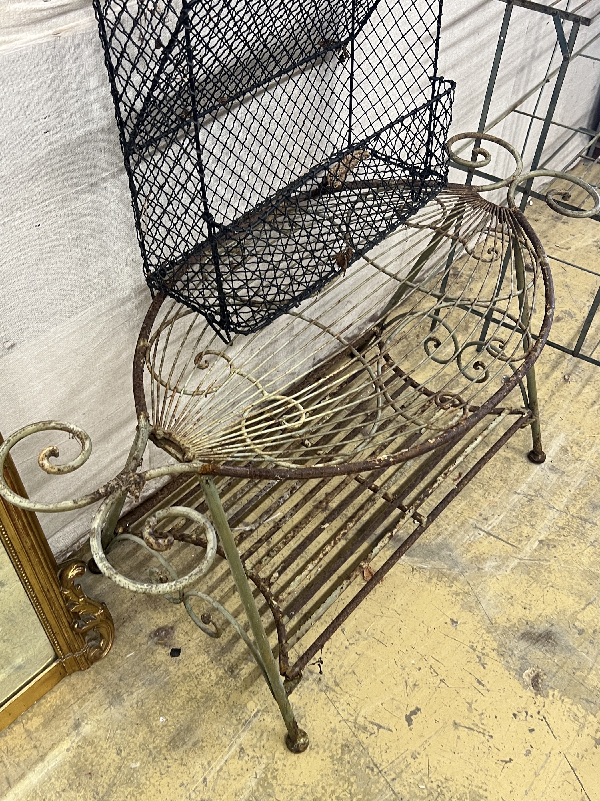 A painted wrought iron three tier pot stand, width 100cm, together with an oval wrought iron garden table and a three tier rack